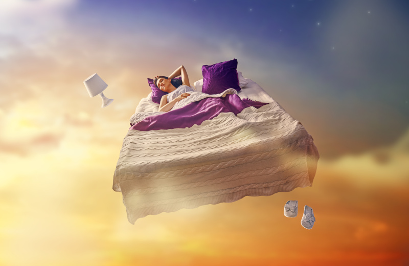 Eine schlafende Frau schwebt mit ihrem Bett